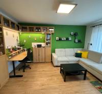 Living room with a sofa, a desk, and a wooden decor floor in a 4-room apartment.