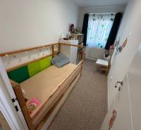 Children's room in a 4-room apartment with a bed, dresser, and colorful curtains.