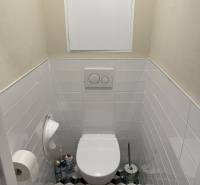 A bathroom in a 4-room apartment with geometric tiles and white tiles.