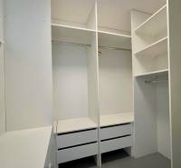 A wardrobe with white built-in shelves and drawers in a 3-room apartment.