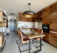 A kitchen of a 3-room apartment with a wooden decor and a dining table.
