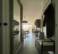 A hallway with a large mirror, coat racks, and a bench in a 3-room apartment.