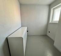 A small room with a dresser in a 3-room apartment, with white walls and a window.