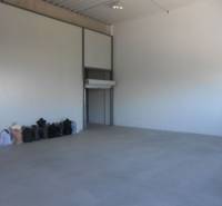 Spacious interior of warehouses and halls with concrete floor and bags along the wall.