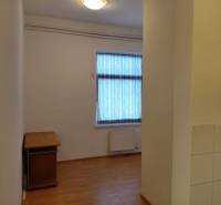 Room with a window, wooden decor flooring, and a table in commercial premises.