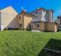 A family house on Hviezdoslavova Street in Piešťany with a grassy yard and a bench.