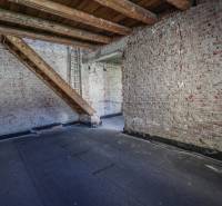 Brick walls and stairs in the attic of a family house with a wooden decor floor.