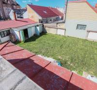 The courtyard of a family house on Hviezdoslavova Street in Piešťany with a lawn and a shelter.