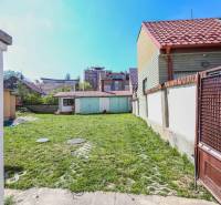The courtyard of a family house on Hviezdoslavova Street in Piešťany with a grassy area and a shelter.