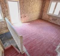 A staircase and brick walls in a family house with large windows and flooring.