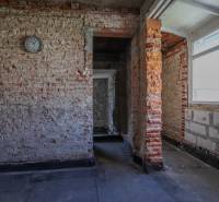 Unplastered brick walls and a simple interior with a window in a family house.