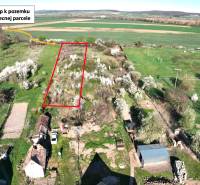 Garden plot in Gemer with an access road, surrounded by blooming trees and fields.