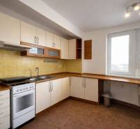 A kitchen in a 3-room apartment with white cabinets, yellow tiles, and a gas stove.
