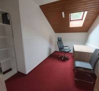 Offices with a red carpet and a ceiling window, a white wall, and wooden ceiling decor.