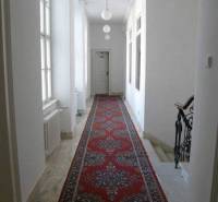 Office interior with hallway, red carpet, and staircase.