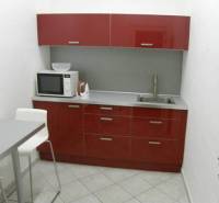 Offices with a red kitchen unit, microwave, and dining table.