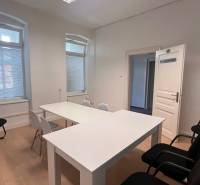 Offices with white desks and chairs, floor with wooden decor.