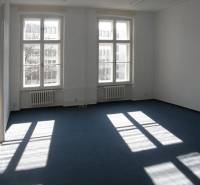 Offices with large windows and blue carpet.