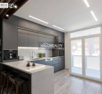 A kitchen in a 3-room apartment with a wooden decor floor and large windows.