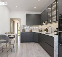 A kitchen with marble elements and dark cabinets in a three-room apartment, with a floor featuring a wooden decor.