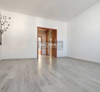 A room in a 3-room apartment with a wooden decor floor and a decorative wall mural.