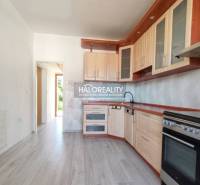 A kitchen in a 3-room apartment with a wooden decor floor and light furniture.