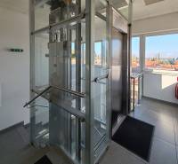 Glass elevator in offices with a view of the rooftops of Trnava.