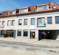 Commercial premises in Trnava with a white facade, red roof, and advertising signs.