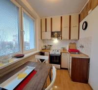 A kitchen in a 2-room apartment with a gas stove and a wooden decor floor.