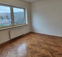 A spacious room with a large window and a wooden decor floor in a 3-room apartment.