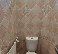 Bathroom with toilet in a 3-room apartment, tiled walls and a window.