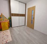 A children's room with a wooden decor floor and a colorful tent in a 3-room apartment.