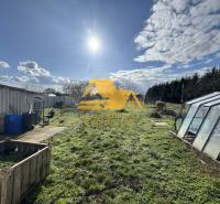 The garden of a family house in Tvrdošovce in Tvrdošovce with a lawn and a greenhouse.