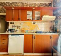 A kitchen in a family house with a wooden decor, equipped with appliances and kitchen cabinets.