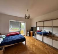 Bedroom in a family house with a bed, wardrobe, and floor with wooden decor.