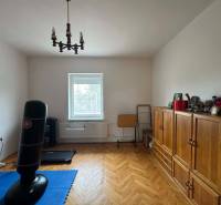 A room in a family house with a wooden decor floor, furniture, and a punching bag.