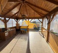 Wooden gazebo with a floor in a family house with a wooden decor, bright and spacious.