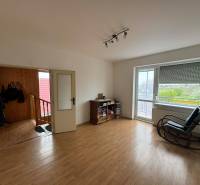 A room in a family house with a wooden decor floor, a swing, and a large window.