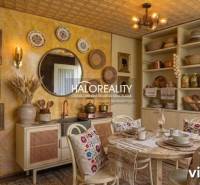 Interior of a kitchen with rustic furniture, decorations, and a view of the garden.
