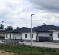 A family house on Leknová Street in Láb with a modern roof and a repaired sidewalk.