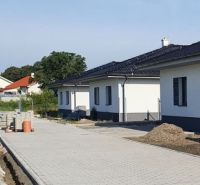 Family houses on Leknová Street in Láb with a paved road and gardens.