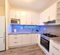 White kitchen in a 4-room apartment with wooden floor decor and modern appliances.
