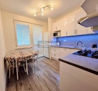 A kitchen in a 4-room apartment with a wood-patterned floor and a dining table.