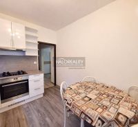 A kitchen in a 4-room apartment with a wooden decor floor and a dining table.