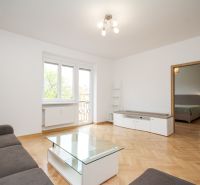 Living room in a 2-room apartment with a sofa, bright room, floor with wood decor.