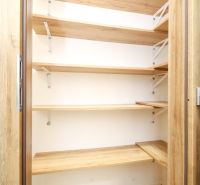 Pantry in a 2-room apartment with shelves and a wooden decor floor.