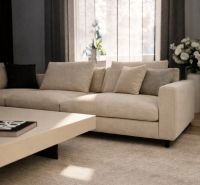 A bright living room with a beige sofa and a coffee table in a family house.