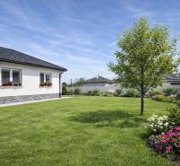 A family house in Zemianska Olča with a well-maintained garden and a flower bed.