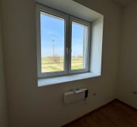 A room with a white window, a view of the garden, a floor with a wooden decor, a family house.