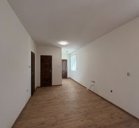 The interior of a family house with white walls and a floor with a wooden decor.